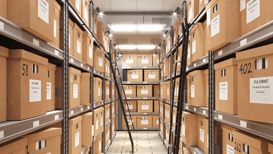 Metal shelving racks filled with labelled brown cardboard storage boxes
